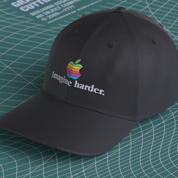A dad hat style cap that has the phrase 'Imagine harder' embroidered on it.